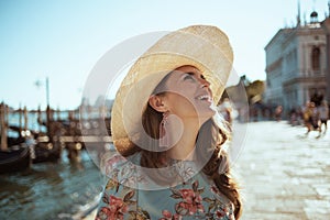 Smiling traveller woman in floral dress having excursion