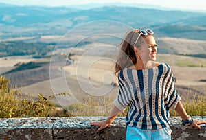 Smiling traveller woman in Tuscany looking into distance