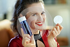 Smiling trendy housewife with makeup remover and cotton pads