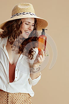 smiling trendy woman in blouse and shorts on beige