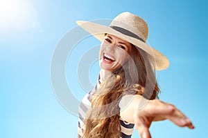 Smiling trendy woman having fun time against blue sky