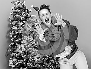 Smiling trendy woman shouting through megaphone shaped hands
