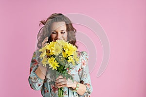 smiling trendy woman using smartphone on pink