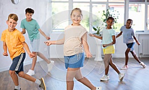 Smiling tween girl learning modern dynamic dances in choreography class