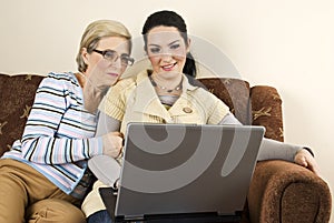 Smiling two women with laptop home