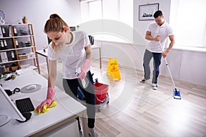 Smiling Two Young Janitor Cleaning The Office