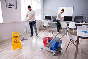 Smiling Two Young Janitor Cleaning The Office