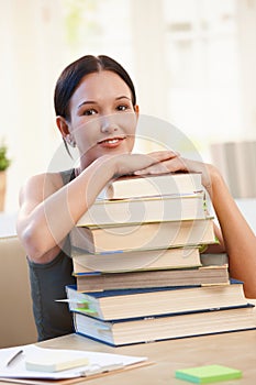 Smiling university student with pile of books