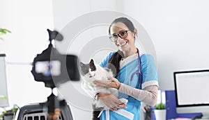 Smiling veterinarian doctor demonstrates cat to camera