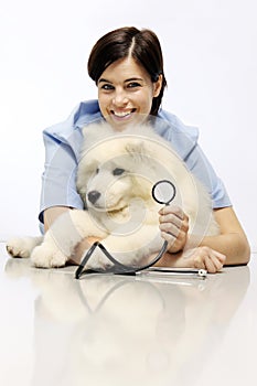Smiling Veterinarian examining dog on table in vet clinic