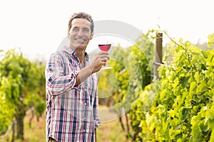 Smiling vintner holding glass of wine