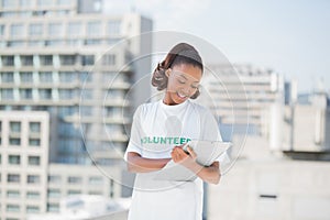 Smiling volunteer woman taking notes holding clipboard