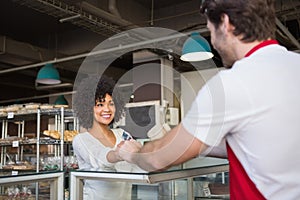 Smiling waiter doing transaction with customer