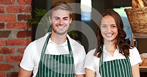 Smiling waiter and waitress gesturing thumbs up