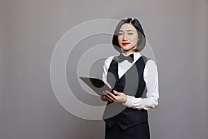 Smiling waitress holding digital tablet