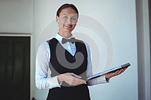 Smiling waitress holding a menu