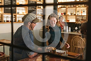 Smiling waitress serving food to a bistro customer