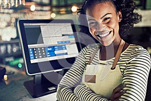 Smiling waitress standing by a restaurant point of sale terminal photo