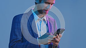 Smiling walking young businessman using smartphone, working in business applications online, answering messages