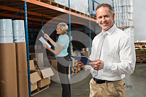 Smiling warehouse manager using tablet pc