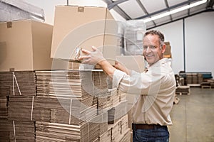 Smiling warehouse worker taking a box