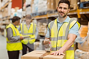 Smiling warehouse workers preparing a shipment