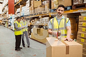 Smiling warehouse workers preparing a shipment