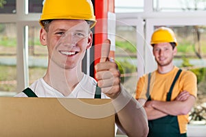 Smiling warehouseman showing thumbs up sign photo