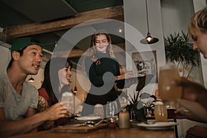 Smiling watiress bringing customers drinks in a bar