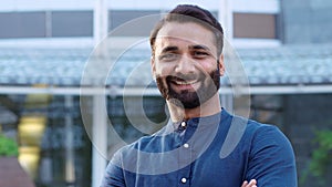 Smiling wealthy indian business man looking at camera outdoor headshot portrait.