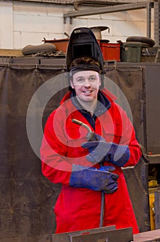 Smiling welder with safety visor and torch