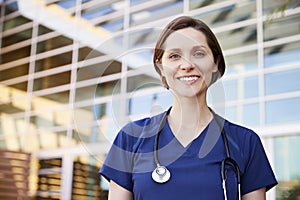 Smiling white female healthcare worker outdoors, portrait