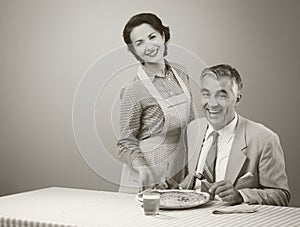 Smiling wife serving dinner