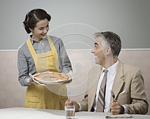 Smiling wife serving dinner photo