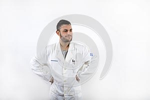 Smiling and willing Young male doctor with beard and arms akimbo isolated on white background