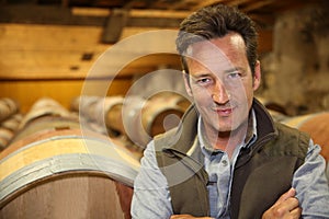 Smiling winemaker in wine cellar photo