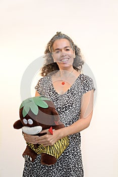 Smiling woman 50+ with plush toy Exotic animal pattern