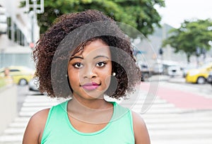 Smiling woman from Africa in a green shirt in city