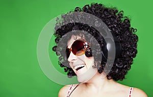 Smiling woman with afro hair listen to music with headphones