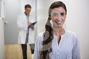 Smiling woman against dentist standing in lobby