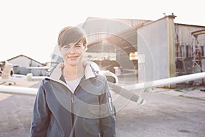 Smiling woman at the airport with light aircraft