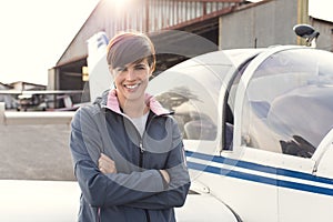 Smiling woman at the airport with light aircraft