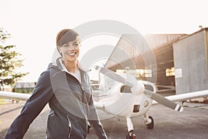 Smiling woman at the airport with light aircraft