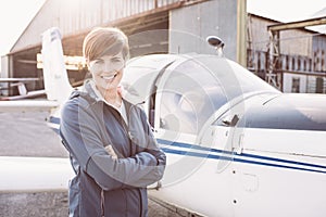 Smiling woman at the airport with light aircraft