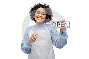 smiling woman in apron holding open sign