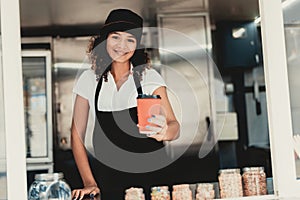 Smiling Woman in Apron Standing in Food Truck.