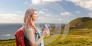 Smiling woman with backpack on big sur coast