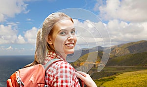 Smiling woman with backpack on big sur coast