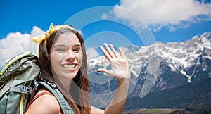 Smiling woman with backpack over alps mountains