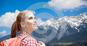 Smiling woman with backpack over alps mountains